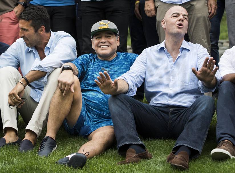 Gianni Infantino, presidente della FIFA, scherza con Diego Armando Maradona. Sulla sinistra Gianluigi Buffon. Epa
